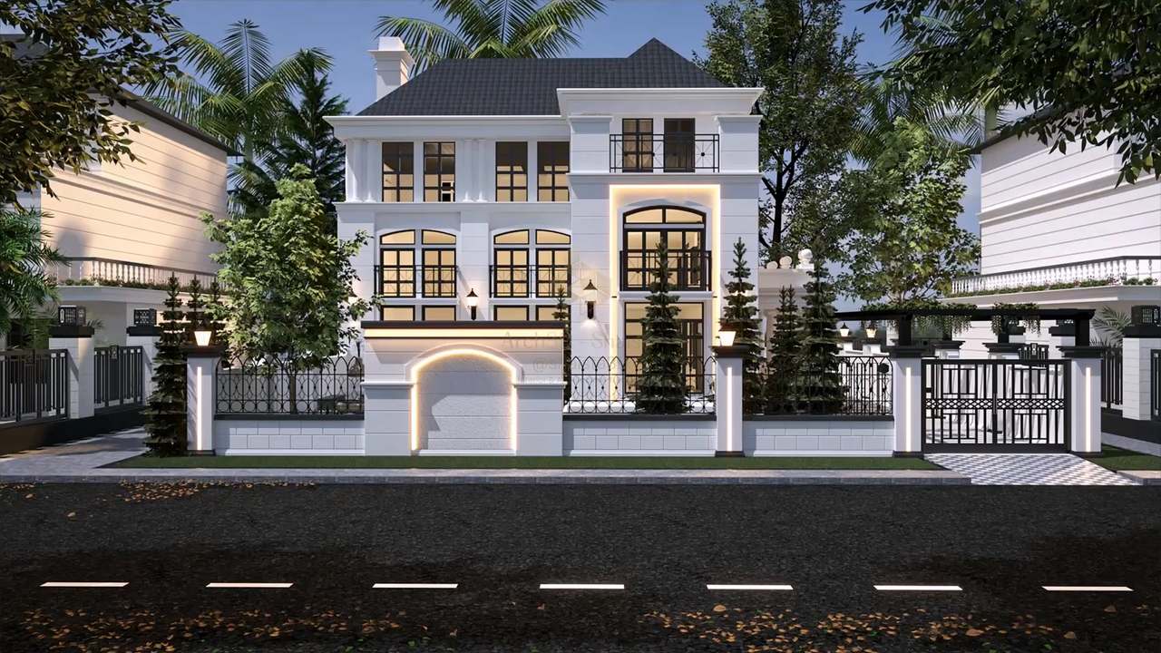 Street view of a three-storey neoclassical villa in white render with a slate hip roof, pilasters and black-framed arched windows, a warm LED-outlined entrance bay, lantern-topped gate piers and ornamental iron railings, set among palms and conifers in soft evening light.