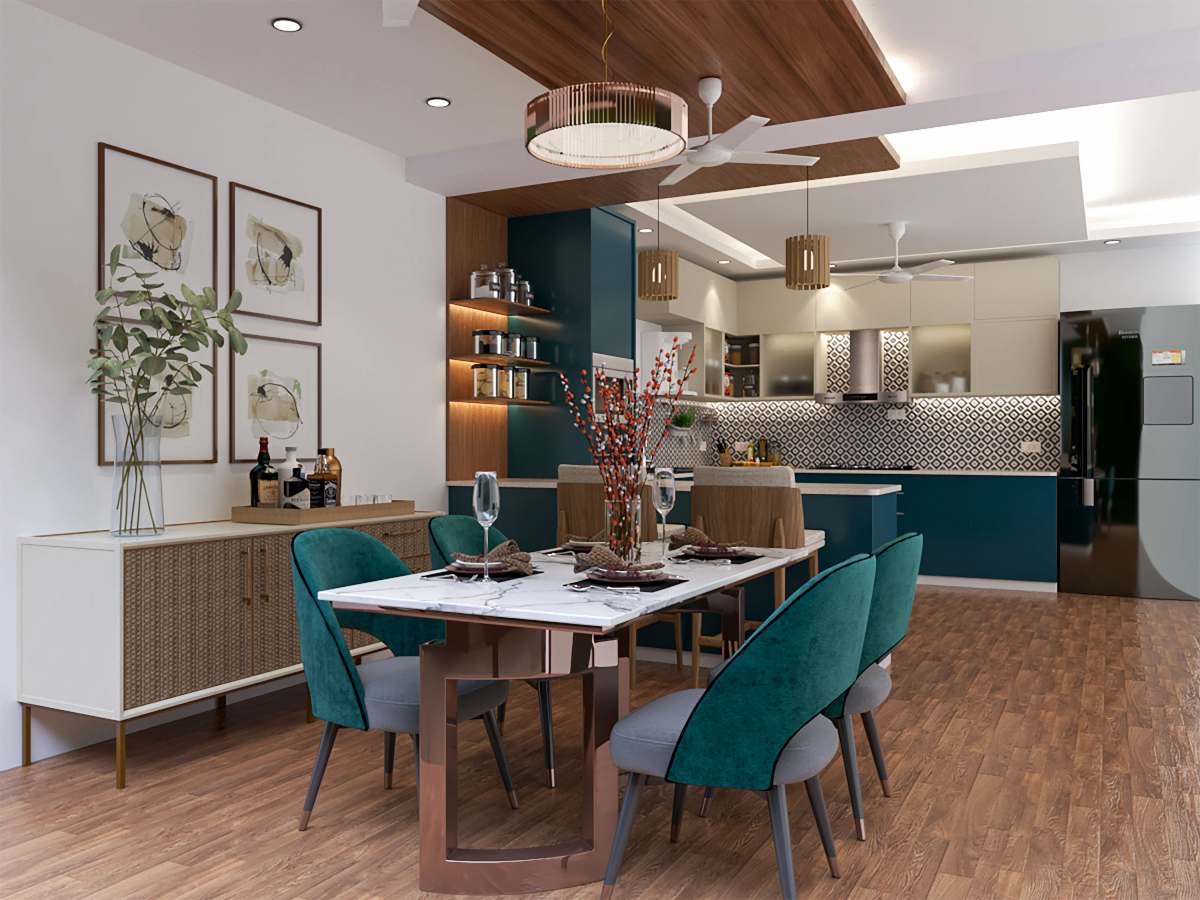 Dining room with teal velvet chairs around a white marble table, framed botanical prints and an open teal and white kitchen behind