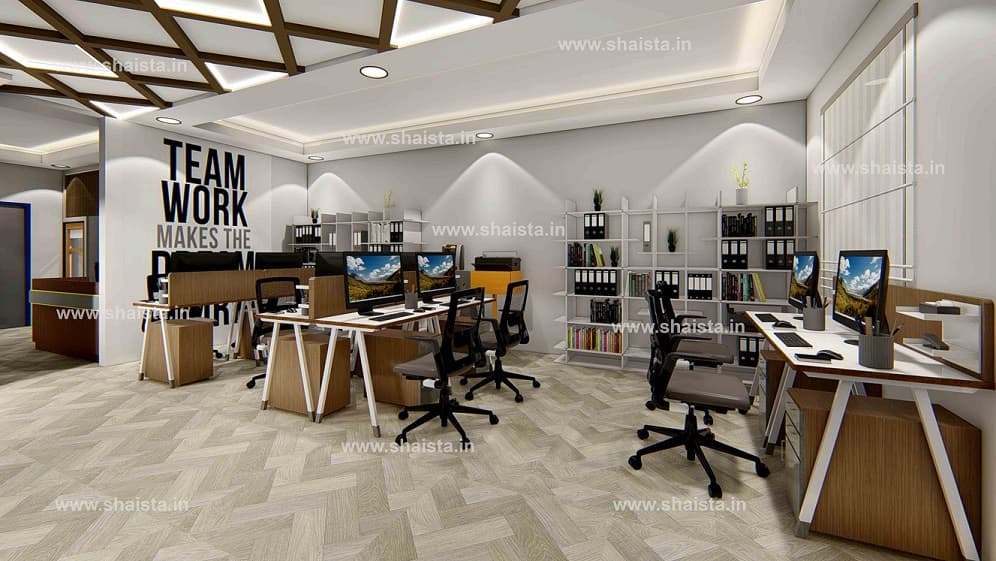 Office floor with a black and white typographic wall reading Team work makes the dream work, behind rows of workstations