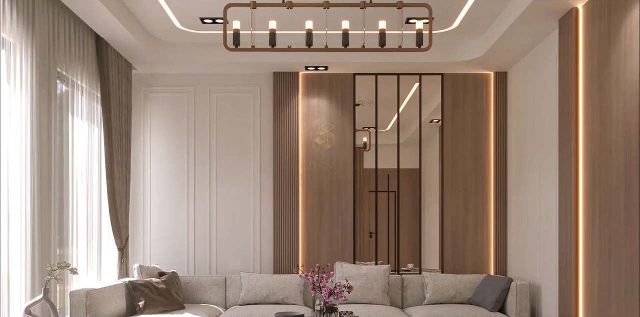 Living-room feature wall with a walnut-slatted panel framed by warm LED reveals, a black-framed mirror inset, white wainscot panels, a stepped cove-lit ceiling and a bronze six-light linear chandelier above a linen sofa, sheer curtains glowing with daylight.
